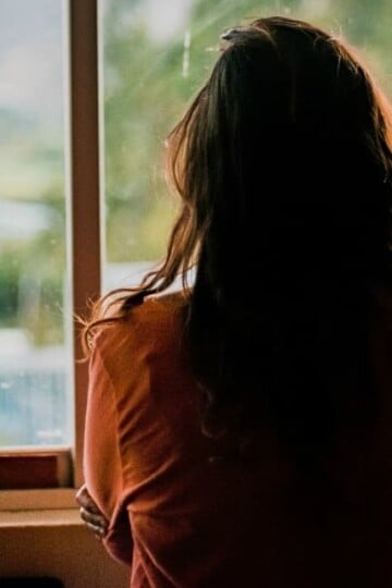 sad woman looking out a window