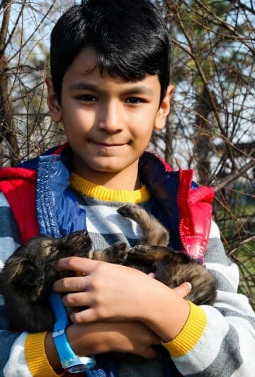 boy holding a small puppy