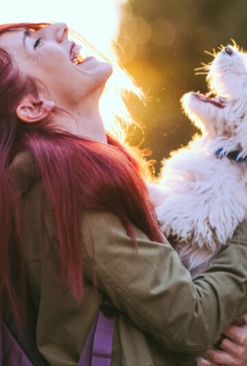 Attractive Redheaded Girl and White Puppy Smiling Together