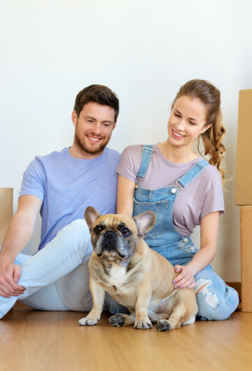 Man and woman with moving boxes and their small dog