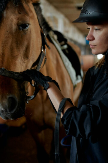 Woman standing with a horse in a stable